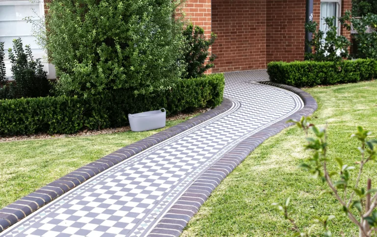 Curved black and white checkerboard garden path with a dark tile border
