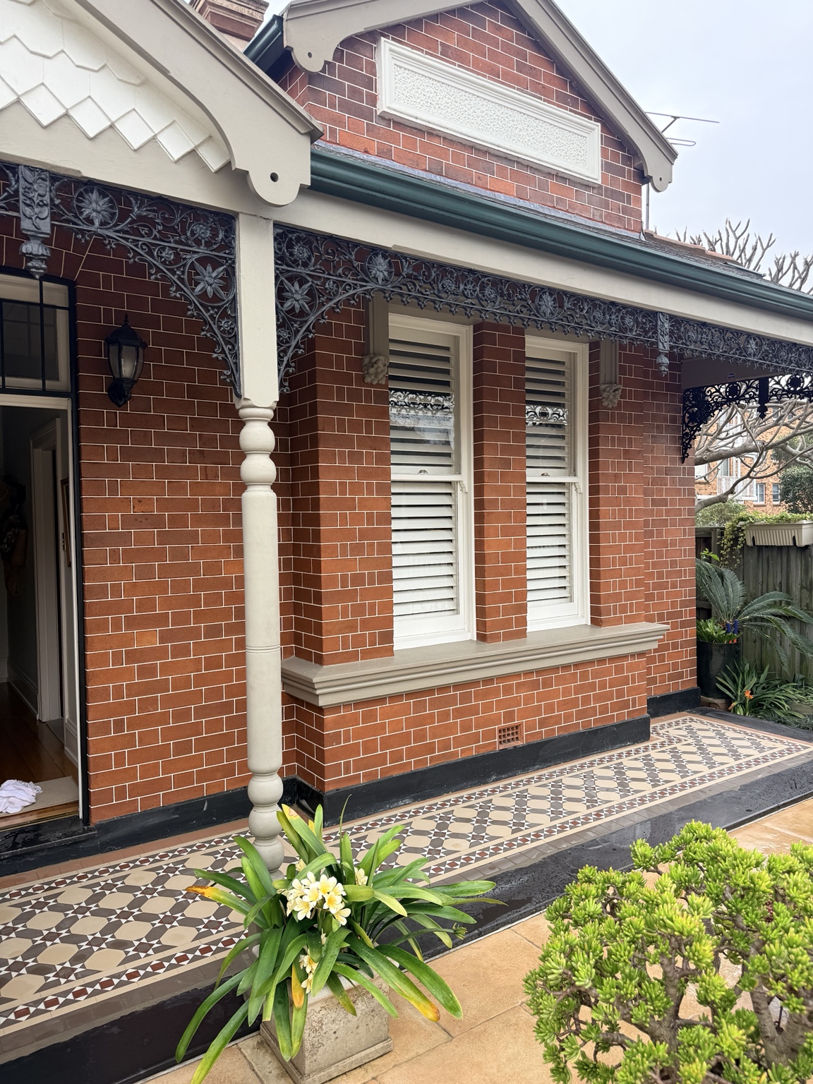 Nottingham and Windsor verandah tile design beside red brickwork and decorative ironwork in Drummoyne
